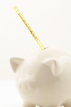 Piggy bank money box. Let's take the temperature of the economy with a thermometer