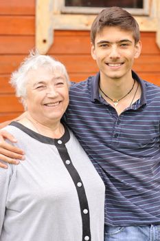 Happy grandmother and grandson in front of house