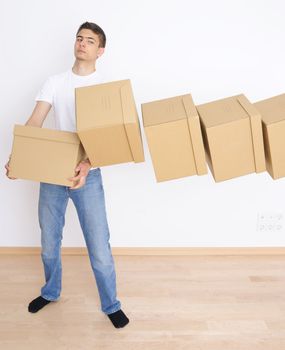 Young man carrying and dropping his stack of moving boxes