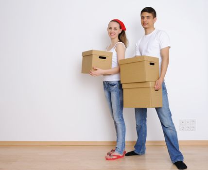 Young couple holding moving boxes