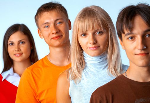 Young people standing in a row on light blue background