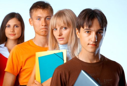  Casual group of college students smiling stand in a row with books on white 