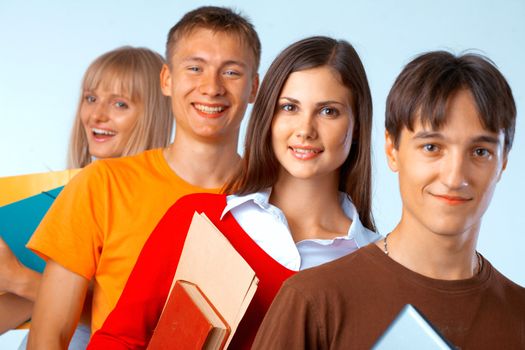  Casual group of college students smiling stand in a row with books on white 