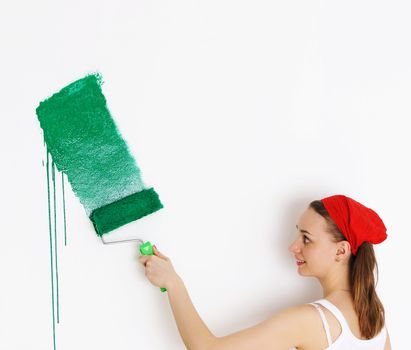 Woman painting interior wall of home with paint roller