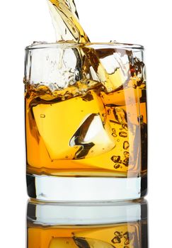 Pouring whiskey in glass with ice isolated on white
