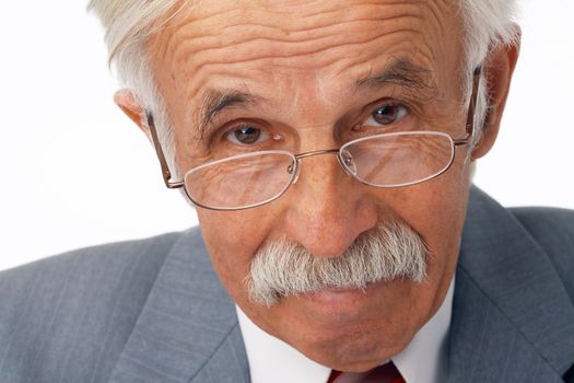 Close-up portrait of an elder businessman in the glasses  looking at you.