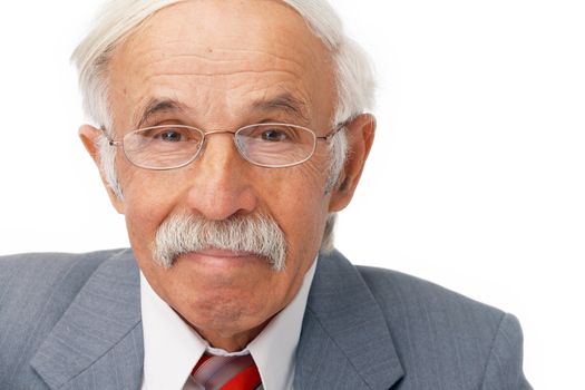 Close-up portrait of an elder businessman looking at you and smiling.