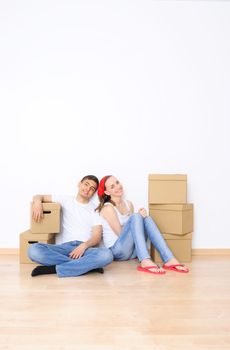 Young couple resting from moving into a new home. Great copy space.