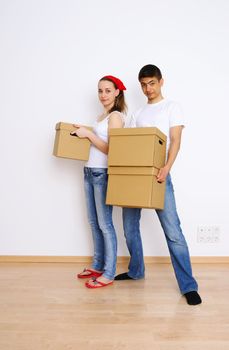 Young couple holding moving boxes
