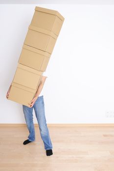 Young man carrying a stack of boxes