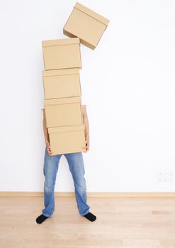 Young man carrying and dropping his stack of moving boxes