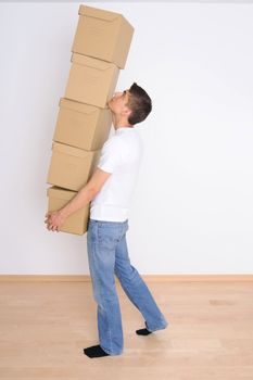 Young man carrying a stack of boxes