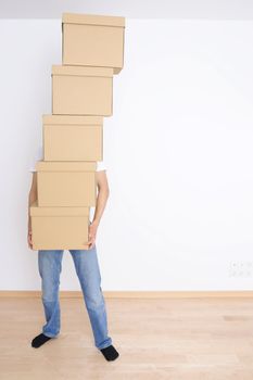 Young man carrying a stack of boxes