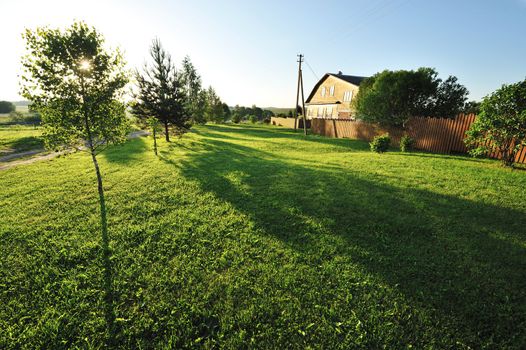 Wooden house with meadow in front of it