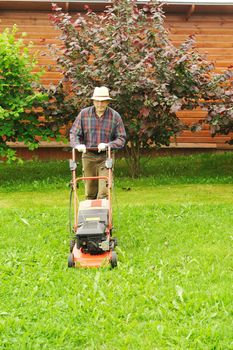 Senior man mowing the lawn