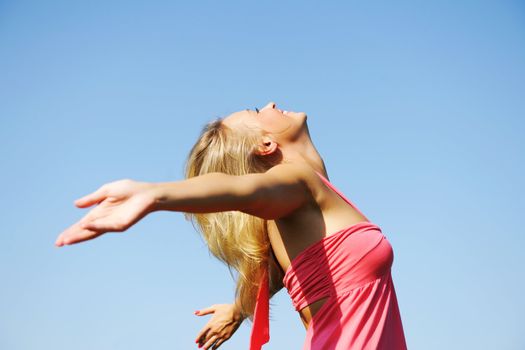 Girl with outstretched arms outdoors against sky