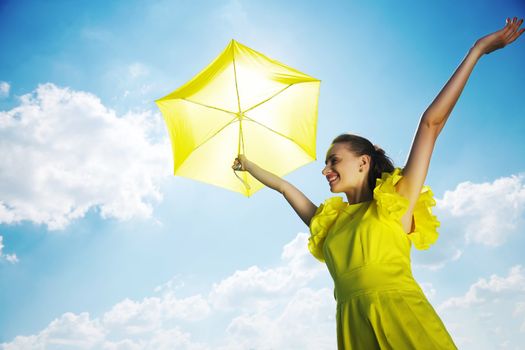 Woman holding umbrella against sun and sky