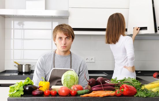 Man unhappy with cooking sitting in kitchen