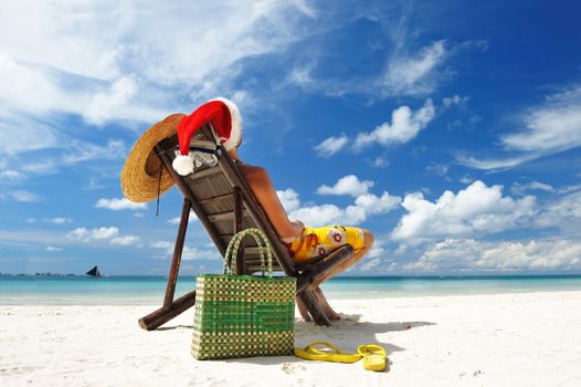 Man relaxing on the beach in santa's hat