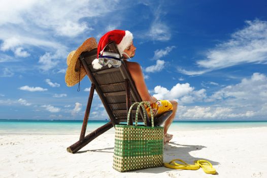 Man relaxing on the beach in santa's hat