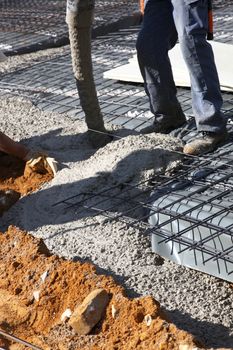 Workman pouring concrete for the flooring and foundation of a new house on a building site Workman pouring concrete for the flooring and foundation of a new house on building site 