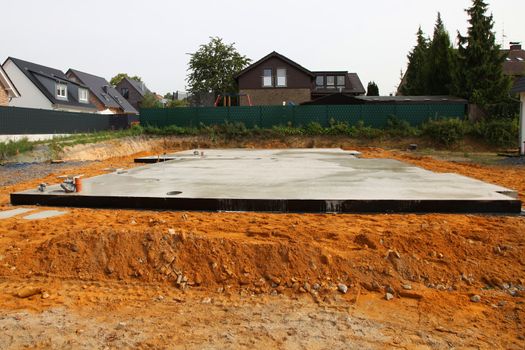 Newly laid floor and foundation for a house in an urban residential neighbourhood with neighbouring properties visible Newly laid floor and foundation for a house in an urban residential neighbourhood with neighbouring properties 