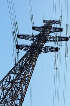 Power lines and electricity pylon  against blue sky