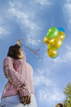 View of a beautiful girl with balloons on nature.