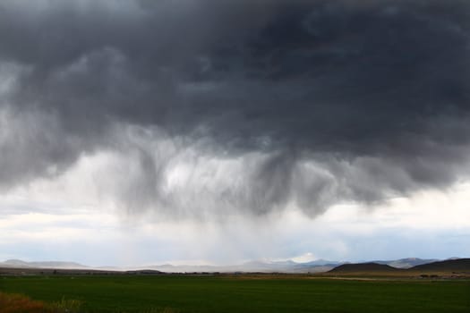 Dark clouds and precipitation from a thunderstorm in rural Idaho.