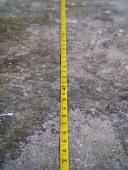 Construction Measuring Tape on Concrete Floor 