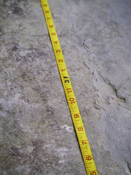 Construction Measuring Tape on grunge concrete floor