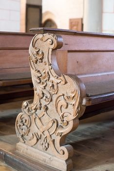 rows of beautifully decorated old wooden church benches