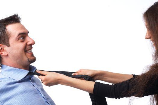 Young couple arguing and struggling, holding the necktie over white.