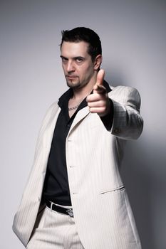 Portrait of a young confident man pointing at you  over white.