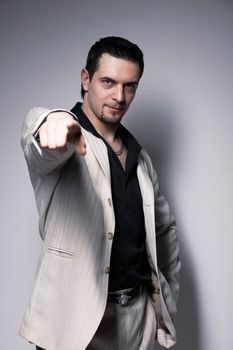 Portrait of a young confident man pointing at you  over white.