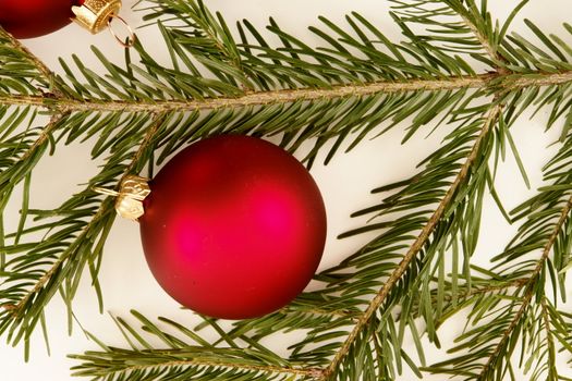 Border of red christmas garland with baubles and ribbons on white.