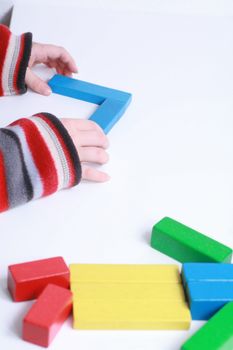 child hands play isolated toy with wooden blocks