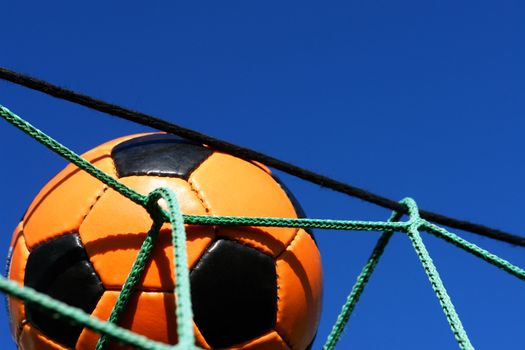 Goal. a soccer ball in a net. outdoors