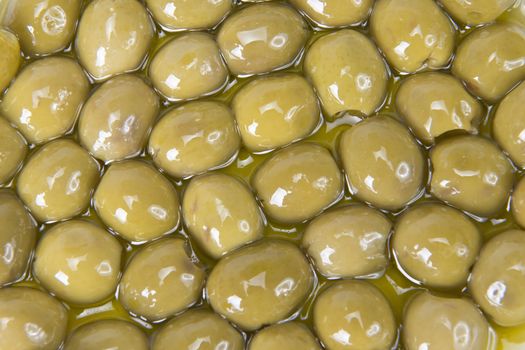 Texture of pitted olives covered in olive oil and ready to eat