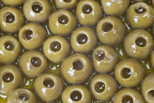 Texture of pitted olives covered in olive oil and ready to eat