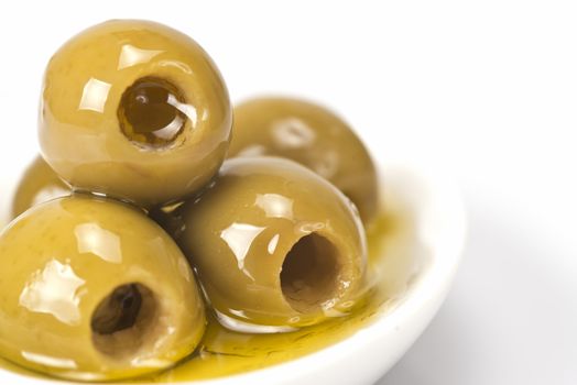 Pitted olives in a saucer isolated on a white background.