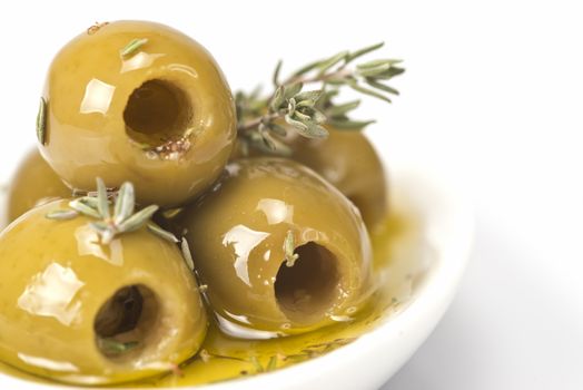 Pitted olives in a saucer isolated on a white background.