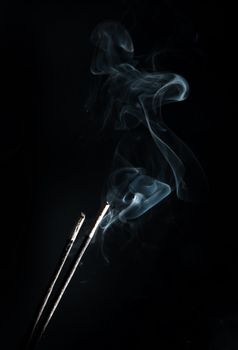 incense with smoke on black background