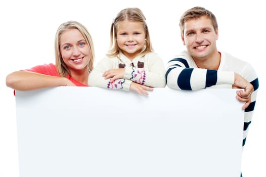 Smiling family with whiteboard in a studio looking at camera