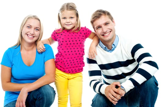 Gorgeous couple posing with beautiful girl child. Isolated over white