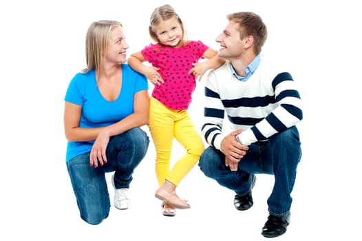 Happy family with kid together isolated on white. Parents squatting with girl child standing in the middle