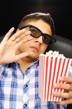 Young man watching movie in 3D glasses at cinema