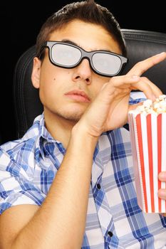 Young man watching movie in 3D glasses at cinema