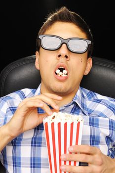 Young man watching movie in 3D glasses at cinema