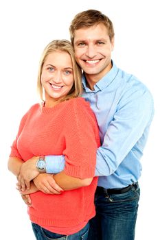 Husband embracing his gorgeous wife from behind. Studio shot